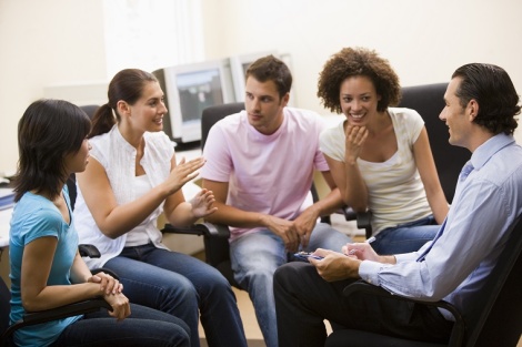 Man giving lecture to four people in computer room